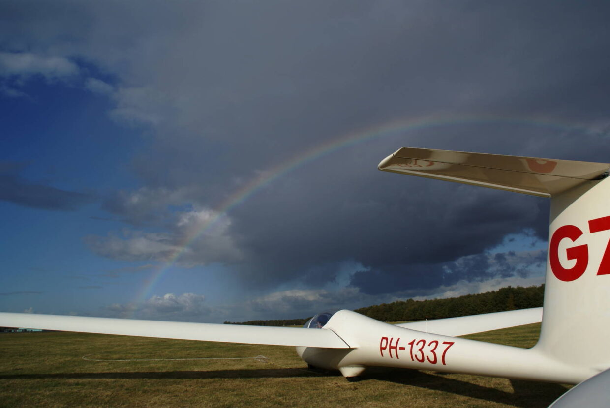 zweefvliegtuig met regenboog